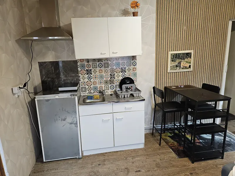Kitchenette and bar table with two bar stools